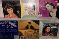 Front view of 6 picture sleeve records featuring portraits and artwork of Paul Weston, Stanley Black, Johnny Costa, Martha Lou Harp, Joni James, and Jane Froman.