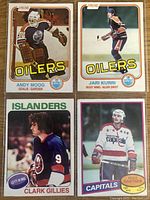 Four hockey rookie cards: Andy Moog (goalie, Edmonton Oilers), Jari Kurri (right wing, Edmonton Oilers), Clark Gillies (left wing, New York Islanders), Mike Gartner (right wing, Washington Capitals).