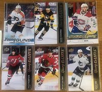 Six NHL Young Guns rookie cards featuring players Connor Bunnaman, Radim Zohorna, Victor Mete, Tyce Thompson, Wyatt Kalynuk, and Kole Lind arranged on a wooden surface.