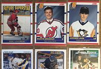 Photo showing 9 NHL rookie hockey cards laid out with various players including Eric Lindros, Martin Brodeur, Jaromir Jagr, Curtis Joseph, Chris Osgood, Quinten Byfield, and Wade Allison.