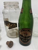 Close view of Carling Red Cap Ale green glass bottle, Mason jar with Stuart Hamilton Canada label and cork stoppers