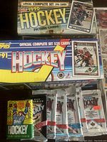 Photo showing two hockey card complete set boxes from Topps (1990 and 1991) along with multiple sealed wax packs.