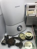 Homech humidifier with several metal gas fittings and pressure gauge laid out.