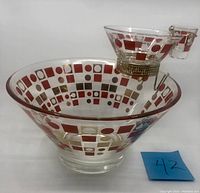 Front view of the chip bowl with attached dip and toothpick holder featuring red and gold square and circle patterns.
