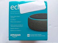 Top and front view of the product box showing the Amazon Echo Dot branding and image of the smart speaker. Details about Alexa voice commands.