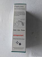 Packaging side showing features of the non-contact design with instructions on how to measure forehead temperature, emphasizing keeping the lens clean.
