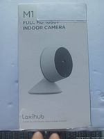 Front view of the Laxihub M1 Full HD 1080P Indoor Camera box showing the camera image and branding