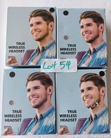 Four boxed pairs of true wireless earbuds arranged in a 2x2 grid, showing the front of the retail packaging with a man wearing the earbuds and the label 'True Wireless Headset'.