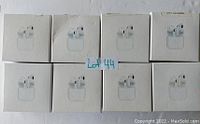 Image showing 8 identical white retail boxes each depicting earbuds similar to AirPods style, arranged in two rows, labeled Lot 44.