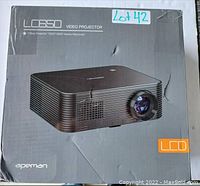 Photo of original packaging box for Apeman LC650 Video Projector showing product image and branding.