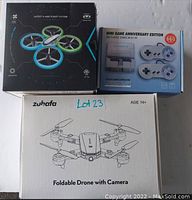 Photo showing two drone boxes and one mini game anniversary edition console box grouped together on a surface.