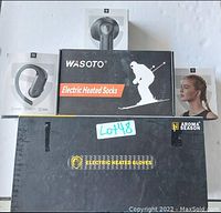 Photo showing all items in the lot: Aroma Season electric heated gloves box, WASOTO electric heated socks box, and three sets of wireless earbuds in white boxes.