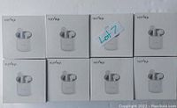 Photo showing 8 HolyHigh brand wireless earbuds in white charging cases arranged in two rows of four, new and untested.