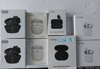 Photo shows eight boxed sets of HolyHigh brand truly wireless earbuds. The boxes are neatly arranged in two rows of four, with black and white color variations visible. One box is marked with a handwritten label 'Lot 9'.