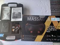 Photo displaying all items in the lot including the TENS 3000 device, electrode pads, wires, battery, instruction manual, and the Shiatsu massager pillow in its box.