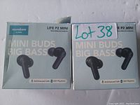 Two unopened retail boxes of Soundcore Life P2 Mini true wireless earbuds in black, placed on a white surface with handwritten label 'Lot 38' on one box.