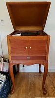 Front view of Crosley console with top open showing turntable and closed cabinet doors.