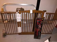 Front view of wood safety gate with metal sides, new hardware, and The Club lock in packaging.