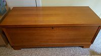 Front view of closed Lane cedar chest showing wood finish and lock on front center.