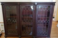 Front view of three-section bookcase showing leaded glass doors and overall design