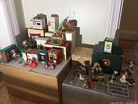 Wide view of Hallmark Keepsake Christmas ornaments in original boxes and assorted collectible figurines including Boyds Bears and Willow Tree angels.