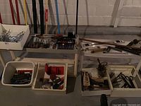 Overview of workbench and bins holding various hand tools including levels, measuring sticks, and hand tools.