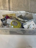 Bin full of assorted new fashion jewelry pieces including earrings and necklaces in packaging