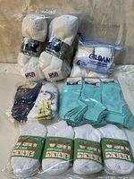 Packaged assorted socks including sport socks with USA embroidery, Gildan ladies ankle socks, and blue Marant socks