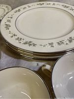 Close-up photo of dinner plates stacked, showing the floral and platinum trim pattern around the edge.