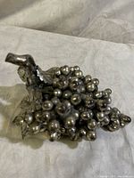 Detailed view of sterling silver overlay grape bunch sculpture with visible grapes and leaves.