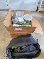 Box and black bag holding assorted screws, nails, and related hardware in various packaging.
