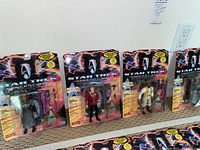 Wide image showing 8 Star Trek Generations collectible action figures in original sealed packaging laid on carpeted floor.