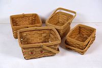 Set of four woven wooden baskets arranged on white background showing various shapes and sizes.