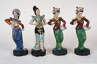 Front view of four porcelain dancer figurines showing detailed traditional outfits and poses.