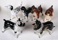 All six ceramic dog figurines shown together from front angle with clear view of colors and shapes