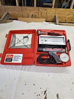 Overview of Sun test equipment kit including timing light, vacuum gauge, analog meter, hoses, all in red plastic case