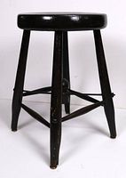 Front view of a sturdy wood stool with black finish and four legs connected with horizontal braces.