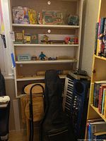 Wide shot showing Yamaha keyboard, Fender guitar with case, multiple toy and collectible items on shelves.