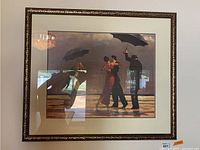 Framed stormy umbrella dance art print in ornate gold-tone frame