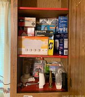 Full view of light bulbs, flashlights, and locks in wooden cabinet