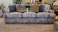 Front view of the Classic House fabric sofa with cushions and pillows arranged on it.