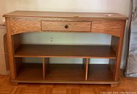 Front view of wooden credenza showing drawer and divided lower shelves.