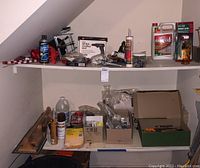 Shelf with boxed cordless drill, glass lantern, assorted hand tools, hardware boxes, and workshop supplies