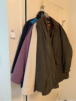 Lot of 5 outerwear pieces hanging on a rack, showing variety of colors and styles