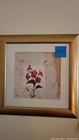 Front view of one framed floral artwork with pink flower on textured paper, gold frame, square shape, size 15x15 inches indicated