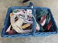 Blue basket with wreath forms, floral wire, ribbons, and craft materials inside