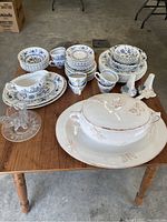 Top view of the Blue Nordic china set displayed on a wooden table showing plates, bowls, cups, saucers, serving platters, a tureen, and decorative candle holders.