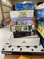 Photo of stacked puzzles and games showing box art and titles