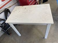 White IKEA desk with stain and marks on top, shown from front and top angles
