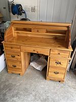 Front view with roll-top open revealing inner shelf, central small drawer and outer drawers